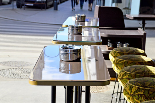 Edelstahl-Aschenbecher auf Stehtischen vor einem Restaurant