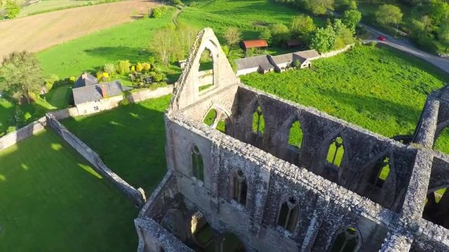 An amazing reverse reveal aerial view over the abandoned Tintern Abbey in Wales, United Kingdom.