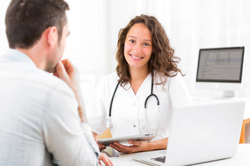 Young doctor showing results on tablet to patient