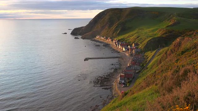A small Scottish coastal fishing village at sunset.