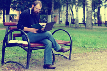 Fototapeta premium man reading books in the park
