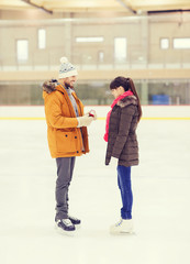 Obraz premium happy couple with engagement ring on skating rink