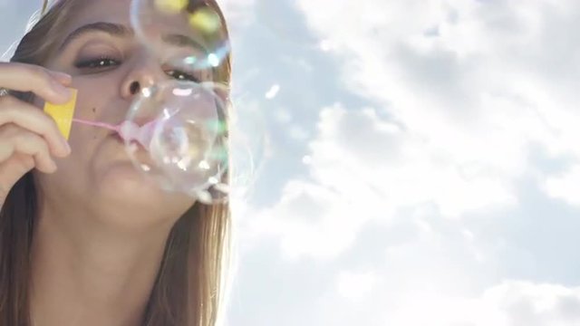 Beautiful woman blowing bubbles outdoors sunshine freedom blue sky is pretty