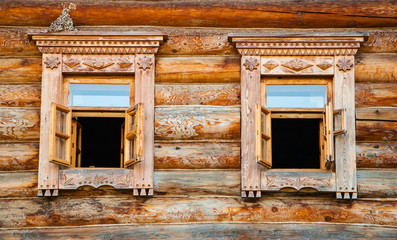 Windows in a log house decorated with wood carvings