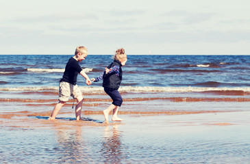 Boy and girl running on beach