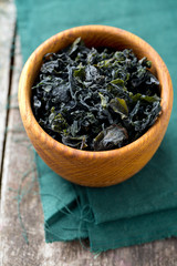 dried laminaria in a bowl on wooden surface