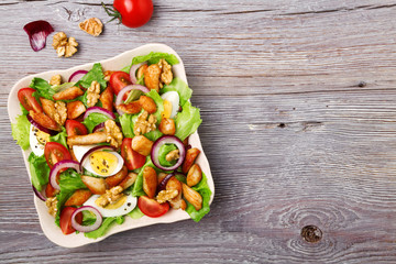 Delicious salad with chicken, nuts, egg and vegetables.