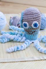 Crocheted woven with colored wool toy octopus close-up, selective focus