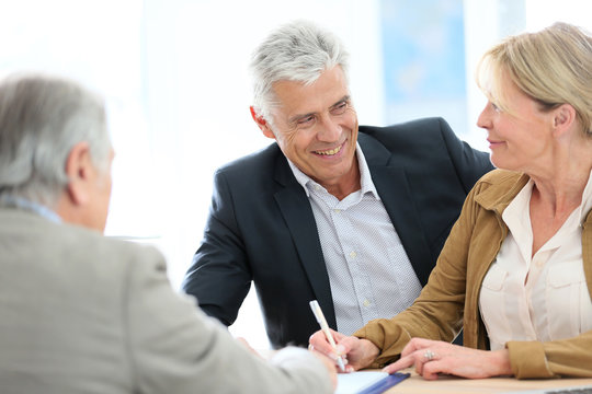 Senior couple meeting real-estate agent for investment