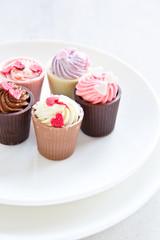 Small cup with heart shape chocolate on white plates