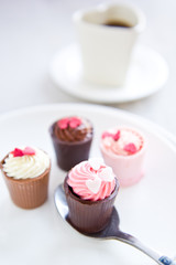 Small cup with heart shape chocolate on white plates