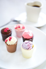 Small cup with heart shape chocolate on white plates