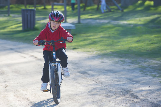 Niño pequeño practicando deporte ciclismo montando en bicicleta en un parque en su rato de ocio