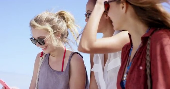 Teenage girls using mobile phone sharing photo of summer vacation on social media close up portrait