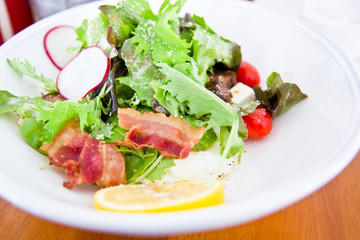 Closeup to salad with lettuce and bacon