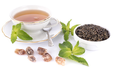 Cup of tea with green dry tea and crystal sugar