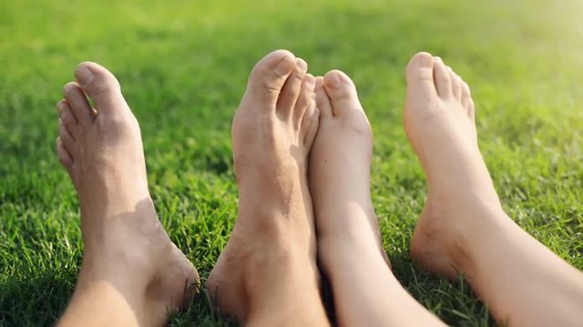 Barefoot feet of young couple in love playing footsie