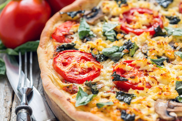 Pizza with cheese and basil close-up.