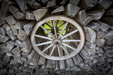 altes Wagenrad und Brennholz, Gartendekoration