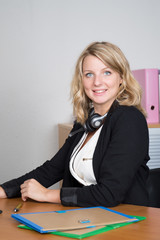 Blond pretty  secretary working with headphone.