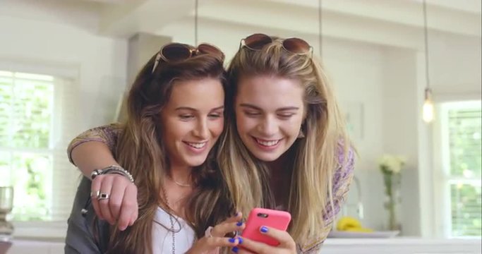 Two Beautiful Friends Planning Road Trip Using Smart Phone At Home