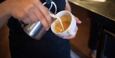 Barista makes latte art, focus in milk and coffee, vintage color