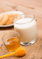 glass of milk with honey and cookie