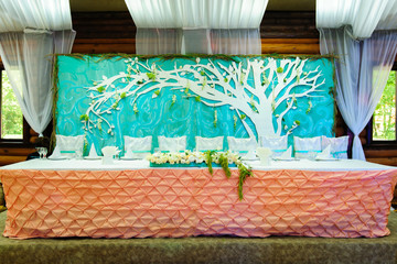 wedding table with flowers under the paper tree in the restaurant