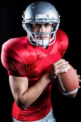 Portrait of determined sportsman holding American football