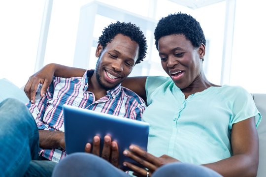 Couple sitting and looking at tablet