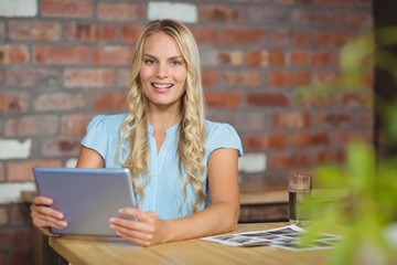 Portrait of cheerful businesswoman holding tablet 