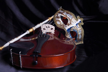 Venetian mask and a violin on a dark background