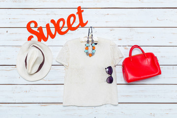 Modern woman's clothes hang on white wooden background