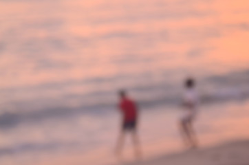 Fototapeta premium Blur children playing on tropical sunset beach abstract background.