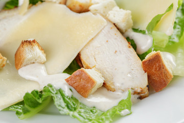 Caesar salad with chicken on wooden table