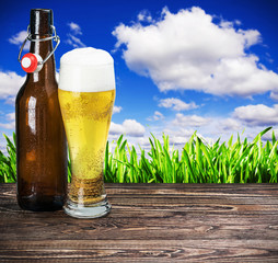 glass of beer and an empty bottle on the table