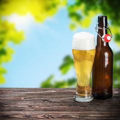 glass of beer and an empty bottle on the table