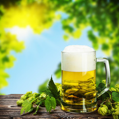 Mug with Beer with hop on a wooden table