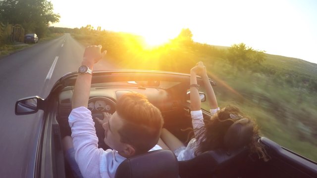Couple driving convertible car cabriolet steadicam shot. UHD 4K stock footage