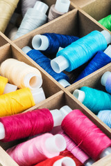 Fototapeta na wymiar Multicolor sewing threads in a wooden box