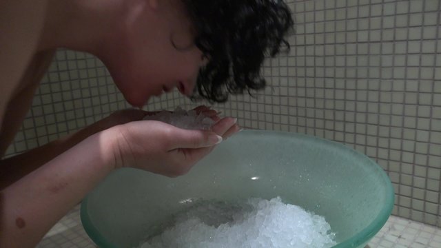 Ice spa bath shock therapy. Female washes face with ice after using sauna bath. UHD steadycam 4K stock footage