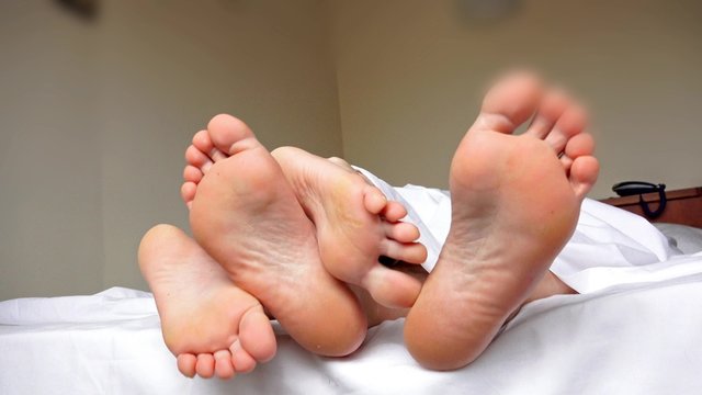 4k Close up Sweet Couple Feet Soles on Bed with White Cover. UHD stock footage