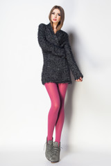 beautiful woman with long sexy legs dressed elegant posing on grey background