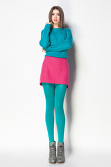 beautiful woman with long sexy legs dressed elegant posing on grey background