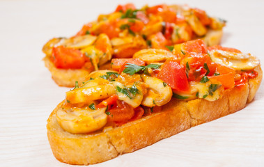tomato bruschetta with chopped vegetables, herbs, cheese and mushroom on toasted crusty ciabatta bread