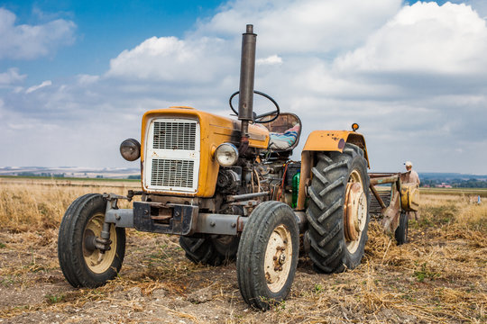 old tractor on harvest field