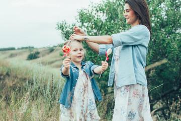 Obraz premium The young mother and daughter on green grass background 