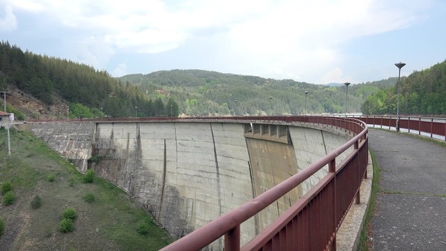 Engineer walking over dam arc crawn pov. Structure security checkup. UHD 4K steadycam pov