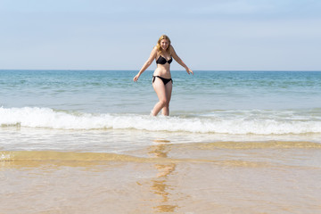 Fototapeta na wymiar Beautiful young girl enjoying the beach in summer