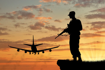 Fototapeta na wymiar Silhouette of a soldier and an airplane